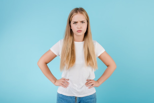 Jovem mulher séria que está isolada sobre o azul