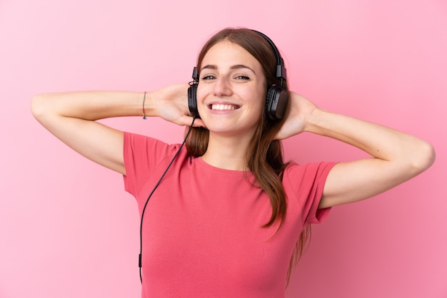 Jovem mulher sobre música parede isolada rosa