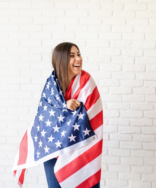 Jovem mulher sorridente com a bandeira nacional dos EUA