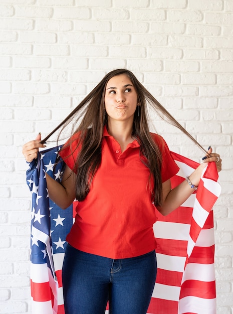 Jovem mulher sorridente com a bandeira nacional dos EUA