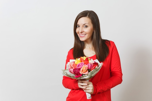 Jovem mulher sorridente com roupas vermelhas, segurando um buquê de flores lindas rosas isoladas no fundo branco. Copie o espaço para anúncio. Dia dos namorados ou conceito do dia internacional da mulher.