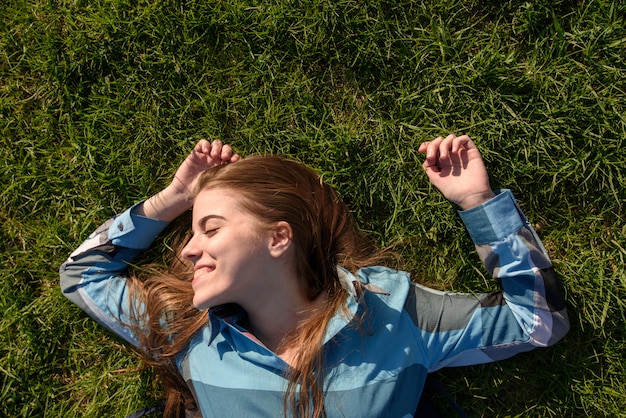 Jovem mulher sorridente deitado na grama