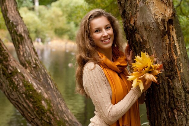 Jovem mulher sorridente no parque outono