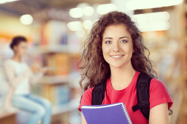 Jovem mulher sorridente segurando um caderno violeta