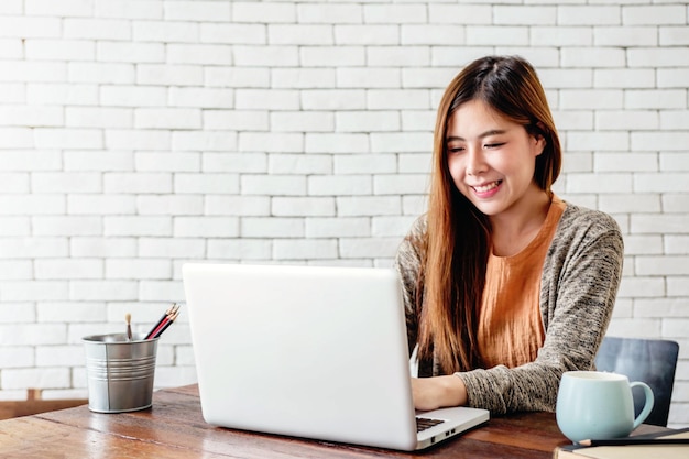 Jovem mulher sorridente usando laptop
