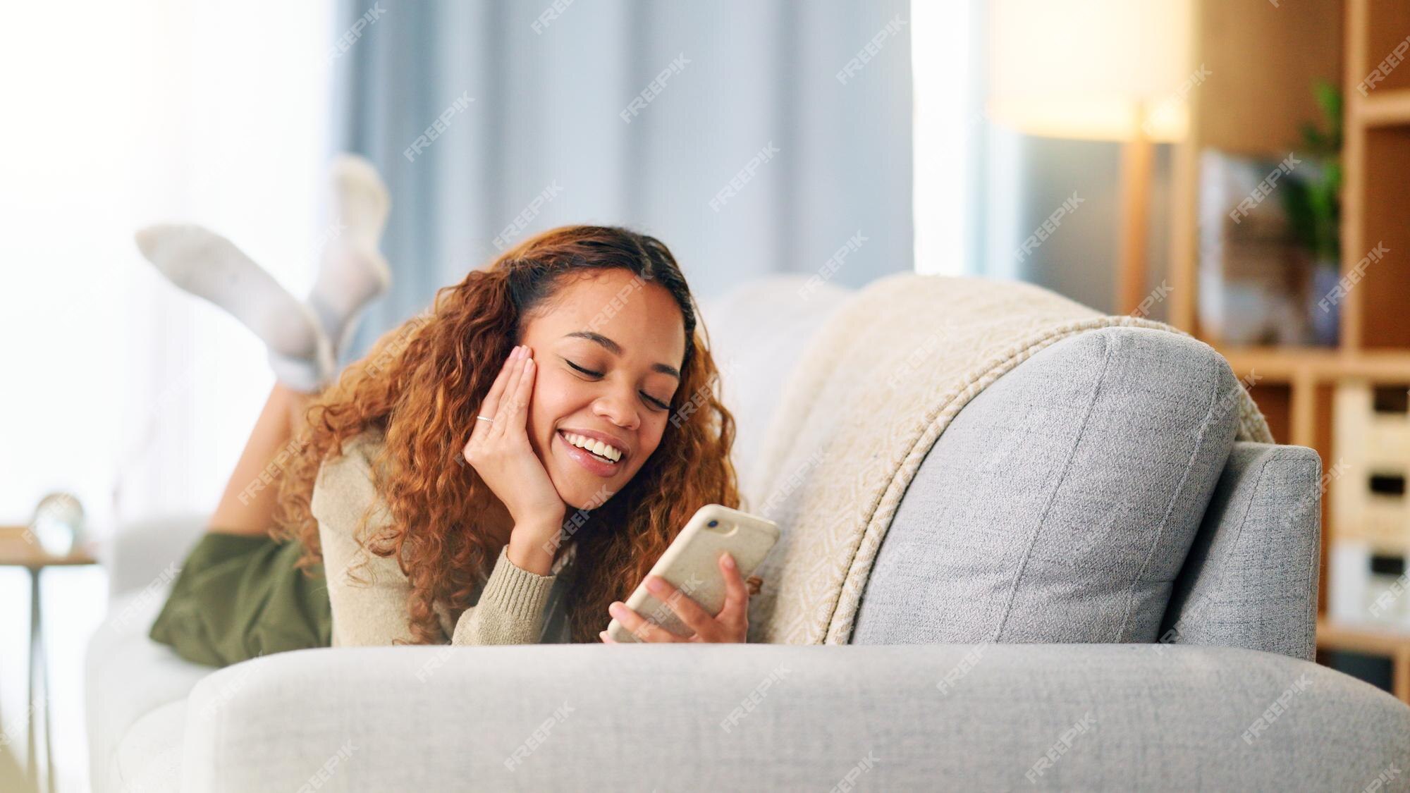 Jovem mulher sorrindo e rindo enquanto enviava mensagens de texto em um  telefone em casa mulher alegre conversando com seus amigos nas mídias  sociais navegando online e assistindo memes engraçados da internet