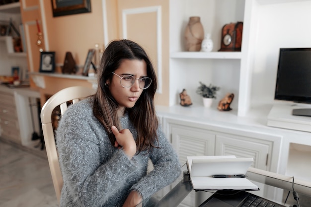 Jovem mulher surda usando linguagem de sinais para soletrar seu nome em uma videochamada online