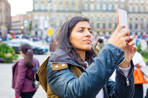 Jovem mulher tirando foto da cidade