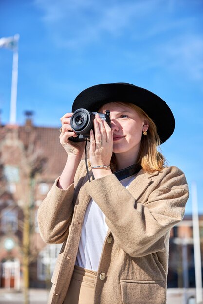 Jovem mulher tirando foto na cidade