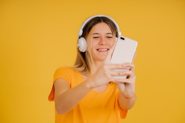 Jovem mulher tirando selfies com um telefone celular.