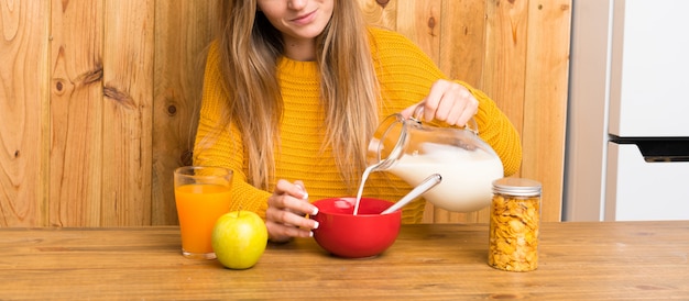 Jovem mulher tomando café da manhã em uma cozinha