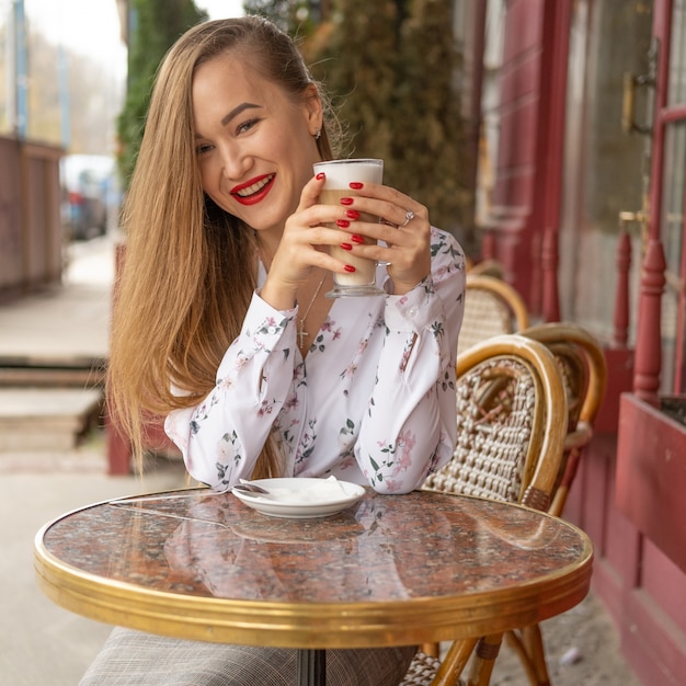 Foto jovem mulher tomando café em um café de rua parisiense
