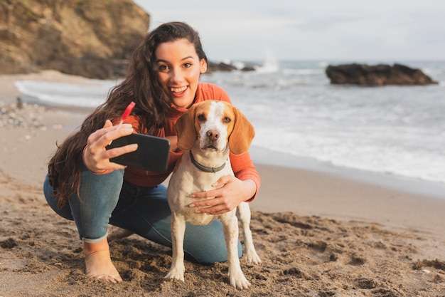 Foto jovem mulher tomando selfie com cachorro