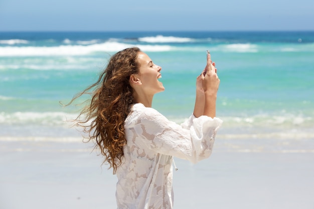 Jovem mulher tomando selfie na praia