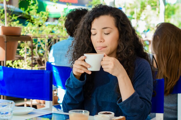 Jovem mulher tomando um café