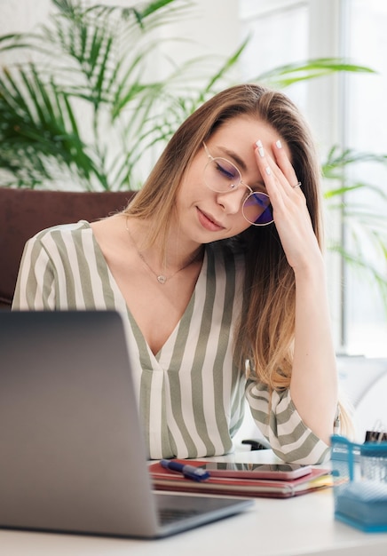 Jovem mulher trabalhando em um computador em seu escritório