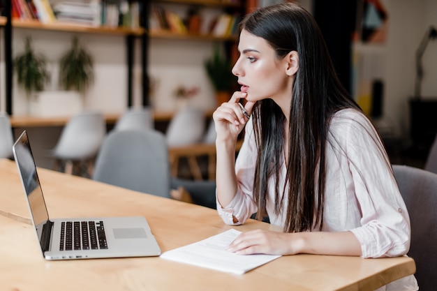 Jovem mulher trabalhando no escritório com laptop