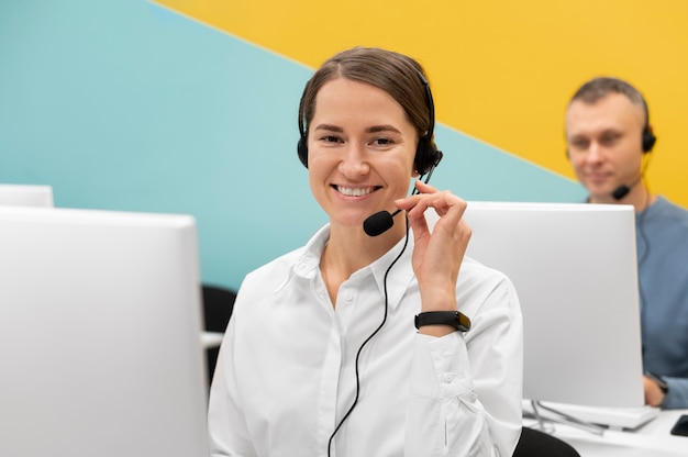 Foto jovem mulher trabalhando no escritório de call center com fones de ouvido e computador