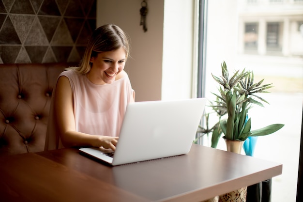 Jovem mulher trabalhando no laptop no café