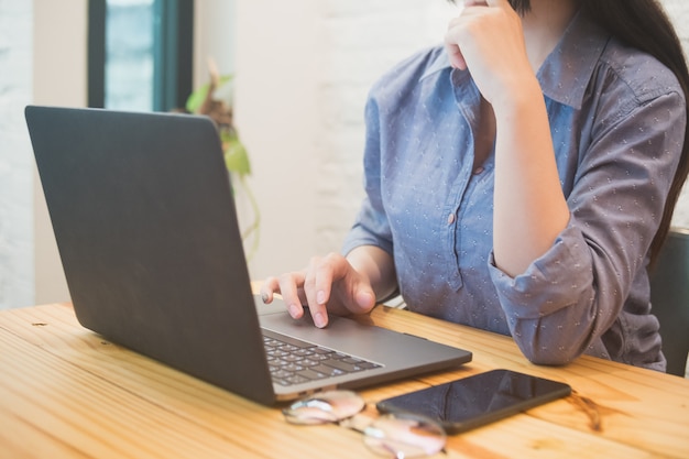 Jovem mulher trabalhando no laptop no café