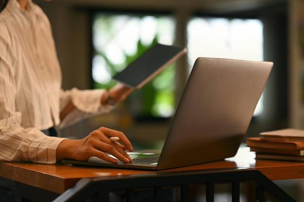 Jovem mulher trabalhando on-line em casa navegando na internet com computador portátil