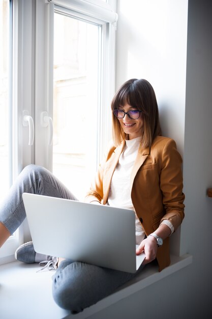 Jovem mulher trabalhando pelo laptop