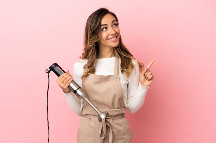 Foto jovem mulher usando a varinha mágica sobre um fundo rosa isolado apontando uma ótima ideia