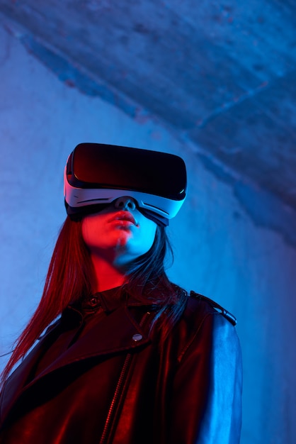 Jovem mulher usando capacete de realidade virtual enquanto usava um casaco