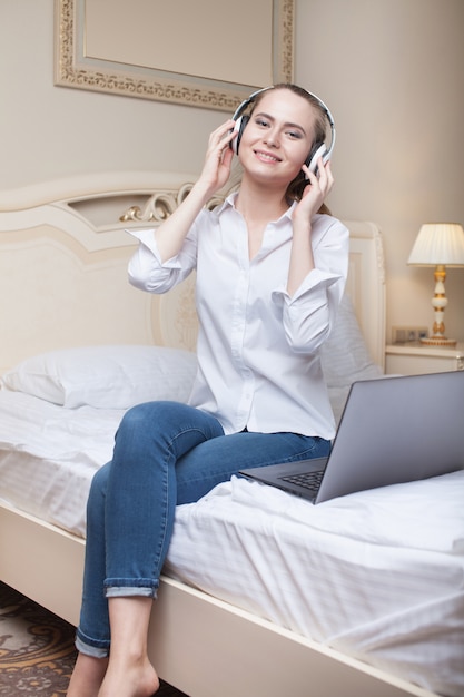 Jovem mulher usando laptop na cama