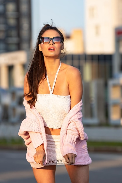 Jovem mulher usando óculos de sol elegantes na rua da cidade