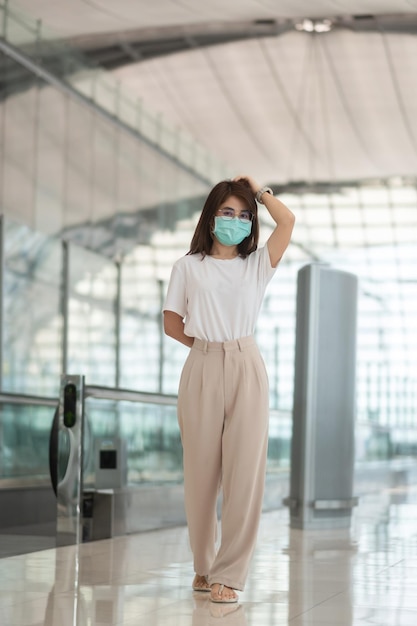 Jovem mulher usando proteção de máscara facial Infecção por doença de coronavírus viajante asiática feliz Hora de viajar após o conceito de dose de reforço de vacina