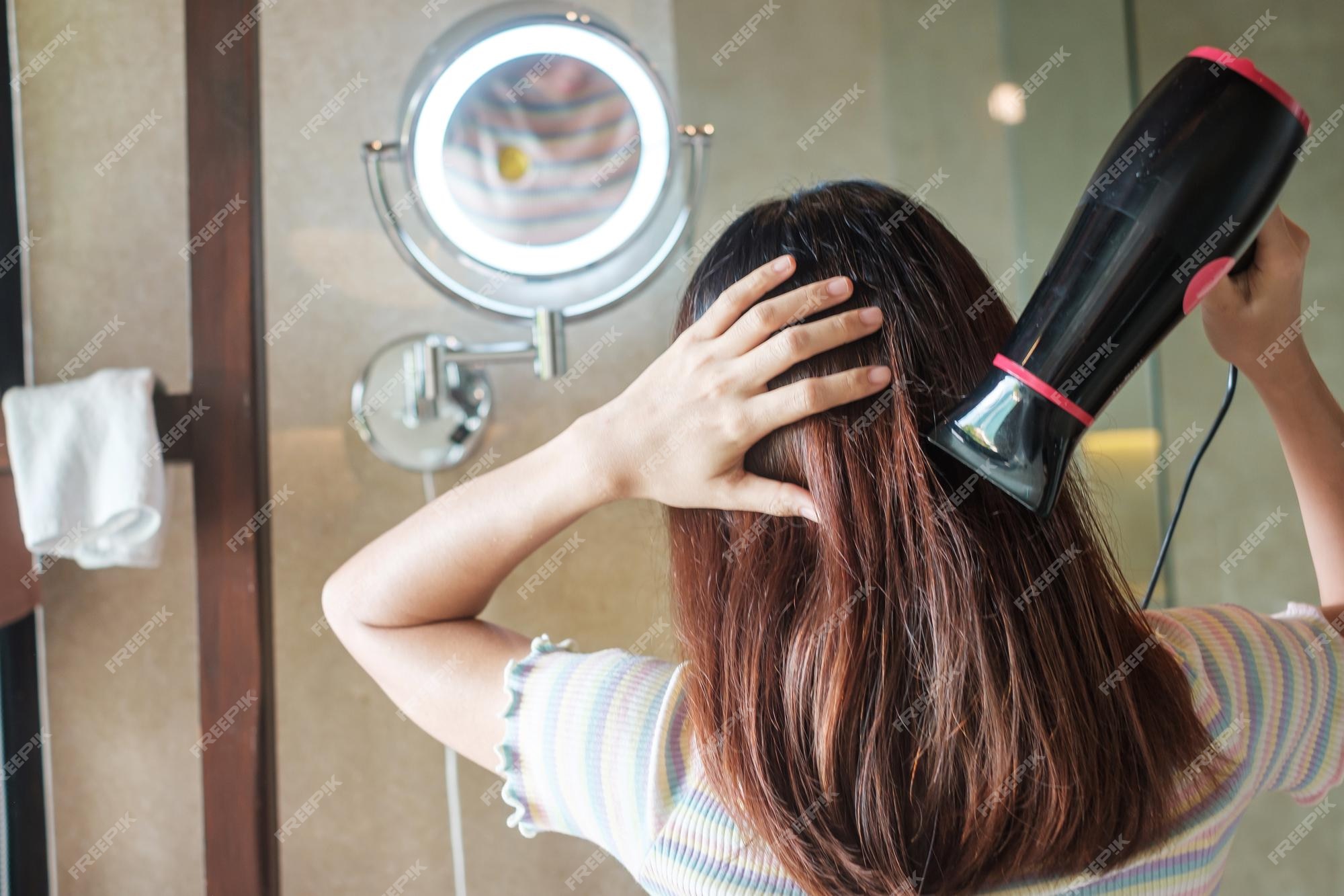 mulher jovem e bonita usando secador de cabelo no salão de cabeleireiro.  close-up do cabelo da mulher no salão de beleza, conceito de penteado  19477832 Foto de stock no Vecteezy