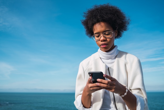 Jovem mulher usando seu telefone celular.