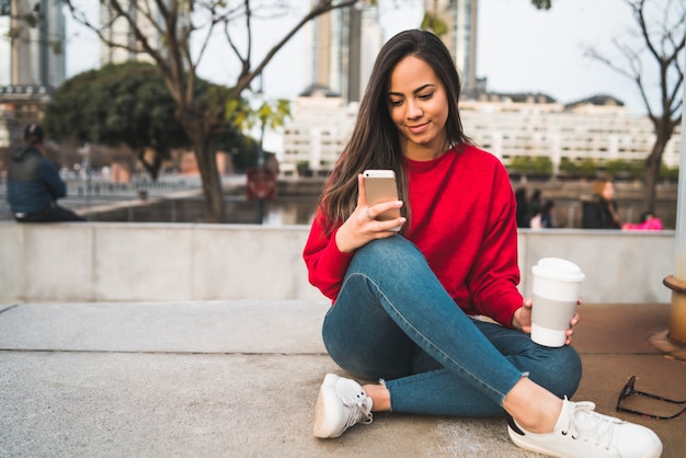 Jovem mulher usando seu telefone celular.