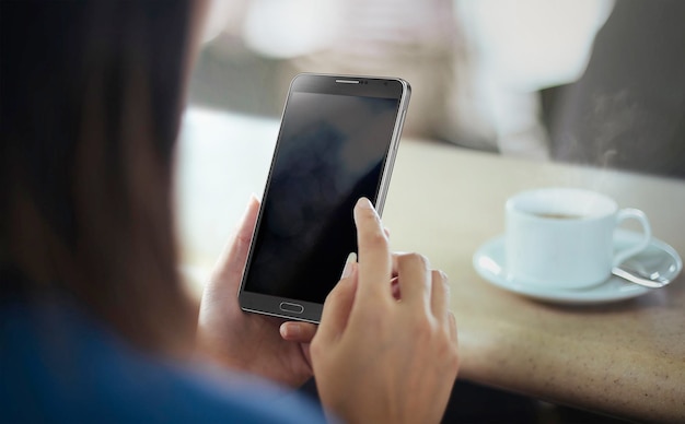 Jovem mulher usando Smartphone na cafeteria