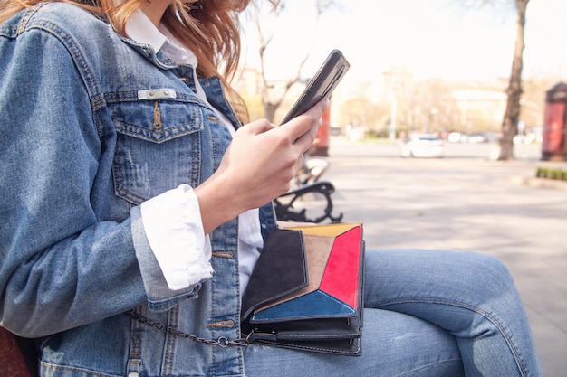 Jovem mulher usando telefone celular ao ar livre.