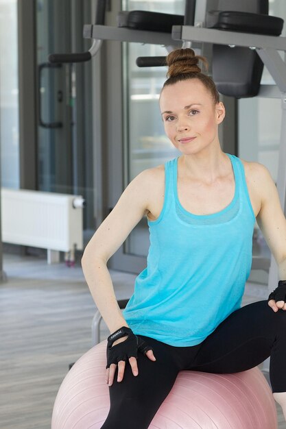 Jovem mulher vestida com um uniforme esportivo faz alguns exercícios físicos.