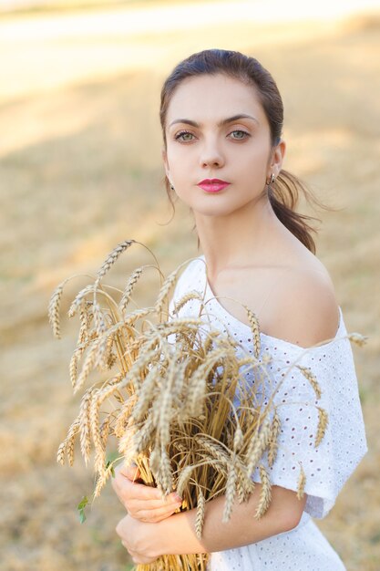 Jovem mulher vestida de branco no campo de trigo. garota no campo de trigo