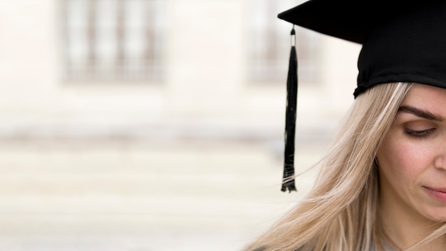 Jovem mulher vestindo um chapéu de formatura com espaço de cópia