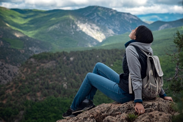 Jovem mulher viajando no topo do penhasco da montanha