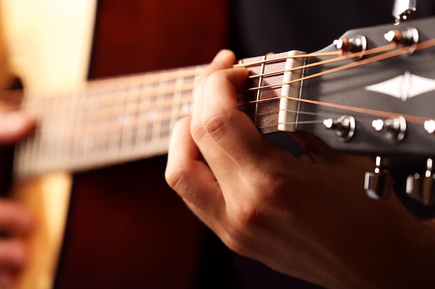 Jovem músico tocando violão de perto