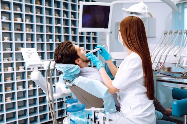 Jovem na cadeira do dentista durante um procedimento odontológico Visão geral da prevenção da cárie dentária