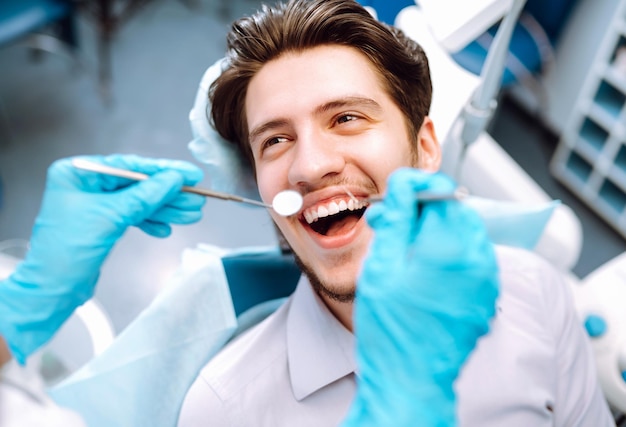 Jovem na cadeira do dentista durante um procedimento odontológico Visão geral da prevenção da cárie dentária