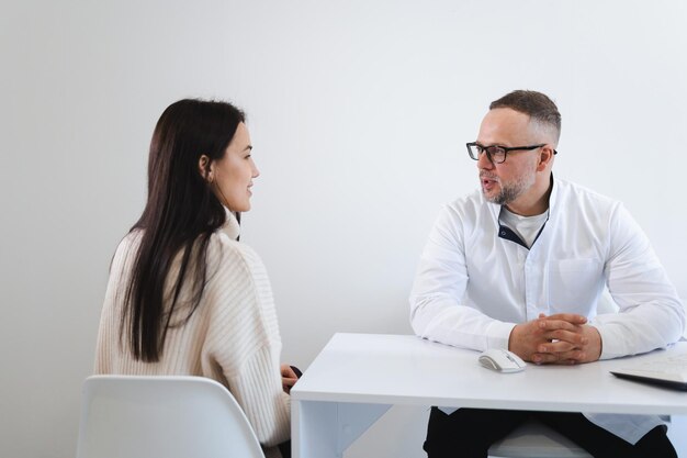 Jovem na consulta médica. médico dando conselhos para paciente do sexo feminino