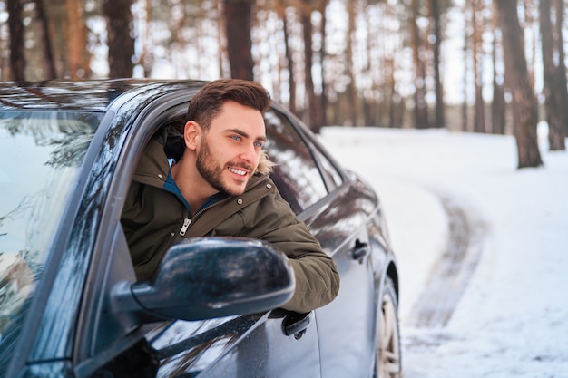 jovem na estrada de inverno do carro