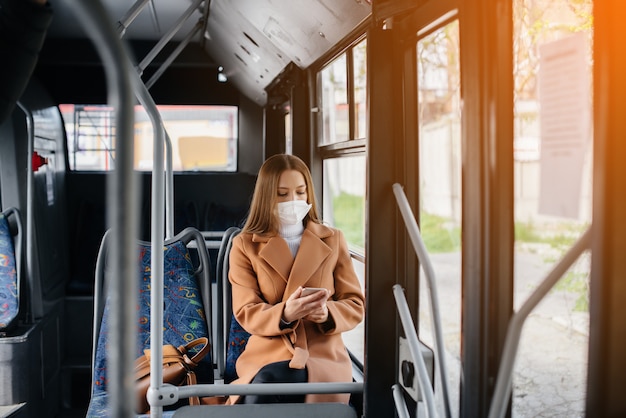 jovem na máscara usa o transporte público sozinho, durante a pandemia.