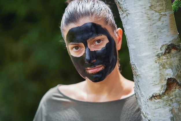 Jovem na natureza com máscara preta no rosto