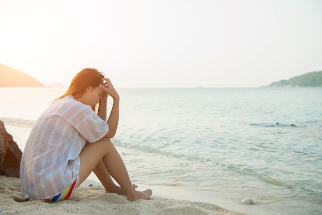 Jovem na praia e estar triste com o conceito