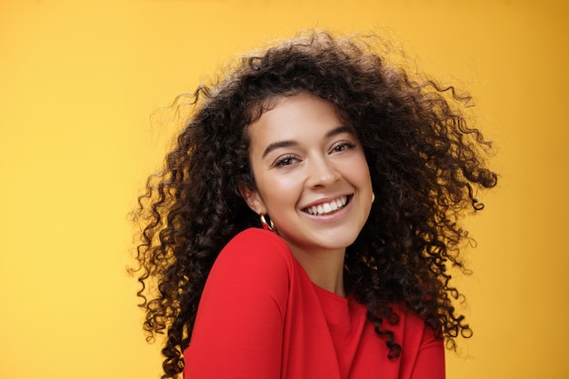 Jovem namorada caucasiana bonita romântica e glamourosa com cabelo encaracolado na blusa vermelha, fazendo pose boba ...