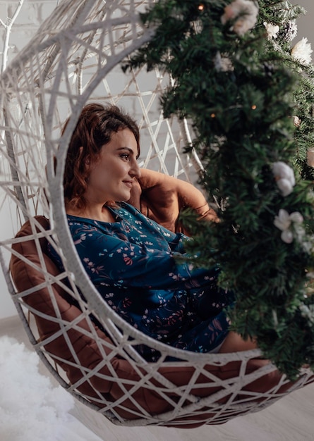 Foto jovem natal estilo de cabelo saudável senhora elegante com um ramo de abeto nas mãos